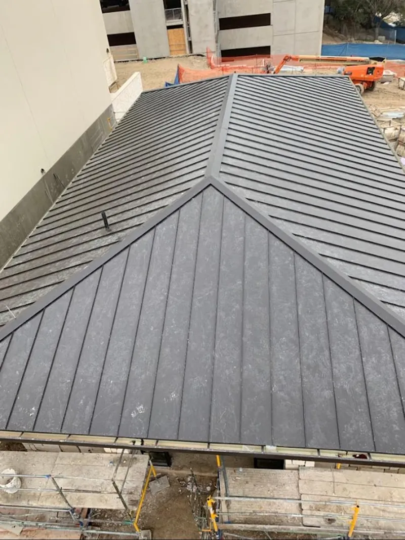 Commercial metal roof construction with crane equipment in Estes Park