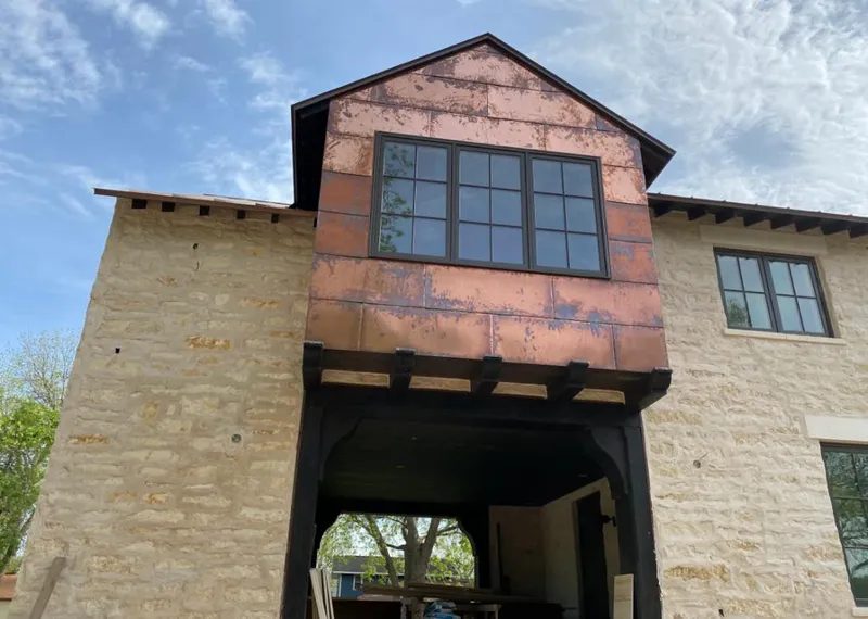 Copper metal panel facade on a stone building for Roof Repair in Estes Park